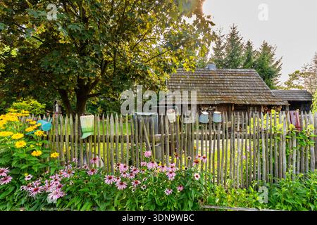 Giardino botanico Kapias a Goczałkowice-Zdrój, Polonia, con fiori colorati, vegetazione lussureggiante, sereni sentieri paesaggistici, e una casa rustica storica Foto Stock