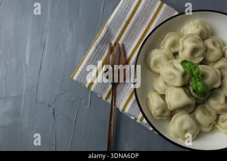 Gnocchi in primo piano su sfondo grigio con spazio per il testo del copyspace. Angolo superiore. Foto Stock