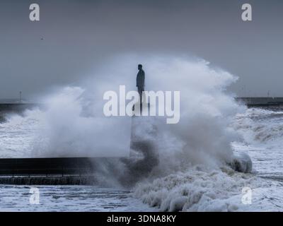 Statua di Roger Casement colpita dalle onde durante un forte vento da est e una marea primaverile Foto Stock