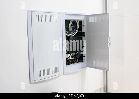Armadio elettrico aperto con cablaggio e apparecchiature di rete all'interno Foto Stock