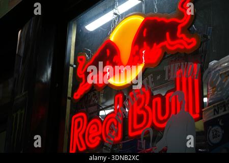 Cartello al neon della bevanda energetica Red Bull su una vetrina Foto Stock