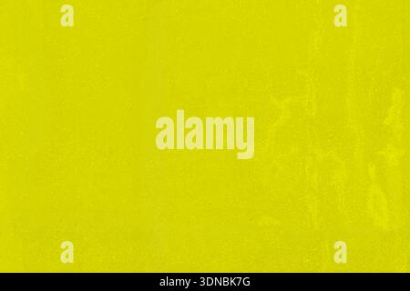 Vecchio muro di cemento giallo-verde con macchie e danni. Foto Stock