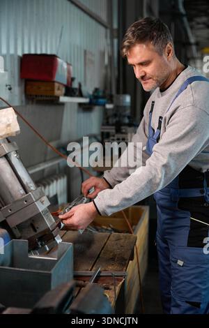 Operaio altamente qualificato che costruisce finestre in PVC in fabbrica Foto Stock