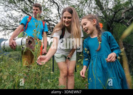 Una famiglia che si diverte a esplorare insieme le meraviglie della natura in un ambiente verde bellissimo e lussureggiante Foto Stock