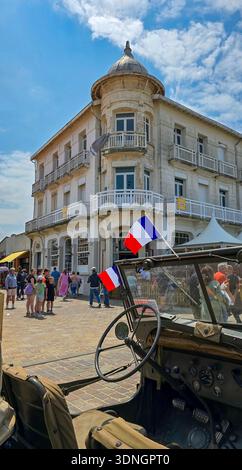 Soulac-sur-Mer, Francia - 8 giugno 2025. Vista del veicolo militare americano Jeep Willys MB della seconda guerra mondiale con le bandiere francesi e statunitensi durante le fes Foto Stock