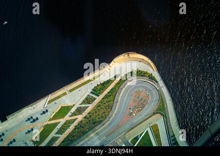 Un'impressionante ripresa aerea verticale che cattura il design architettonico contemporaneo di una passeggiata sul mare. L'immagine presenta linee geometriche pulite. Foto Stock