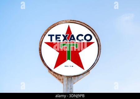 New Hartford, New York - 1° febbraio 2026: Insegna circolare Texaco a luce neon contro il cielo blu, Texaco è uno dei marchi di carburante più riconoscibili del settore Foto Stock