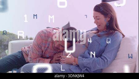 Partner pendente che sdraia la testa su una donna incinta che culla la pancia sul divano di casa, denim, lettere sovrapposte Foto Stock