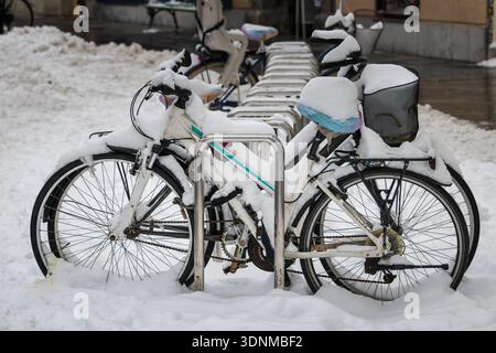 biciclette coperte di neve parcheggiate in inverno Foto Stock