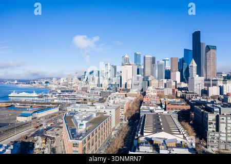 Una fotografia aerea di un drone cattura gli scintillanti grattacieli dello skyline del centro di Seattle che si innalzano sopra il lungomare di Puget Sound, con la città... Foto Stock