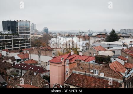 Vista urbana sul quartiere di Vracar con tetti di tegole rosse, edifici residenziali e architettura moderna sotto un cielo coperto a Belgrado, Serbia. Foto Stock