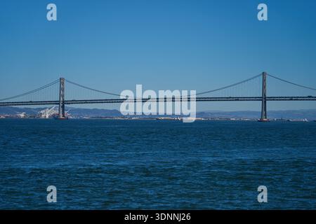 San Francisco, Stati Uniti - 28 ottobre 2025 - l'iconico Bay Bridge si estende attraverso le acque blu profonde sotto un cielo limpido Foto Stock