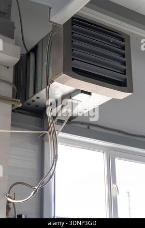 Unità di ventilazione industriale con condotto dell'aria e diffusore con feritoia montato sotto il soffitto. Apparecchiature HVAC in fabbrica o in officina per il comando della climatizzazione Foto Stock