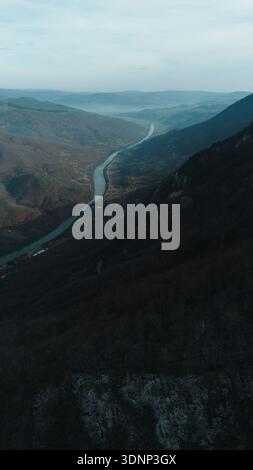 Vista verticale aerea delle spettacolari scogliere calcaree nel Parco Nazionale di Tara che si affaccia sul fiume Drina e sulle valli montuose in inverno senza Foto Stock