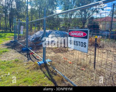 Fotografia di un segnale di pericolo su una barriera di recinzione che avvisa la gente di amianto in un piccolo cantiere nel nuovo Galles del Sud, Austra Foto Stock