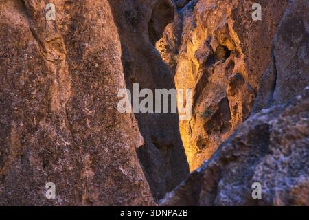 La luce del sole dorata illumina le formazioni rocciose del deserto del Mojave con la stretta Crevice Foto Stock