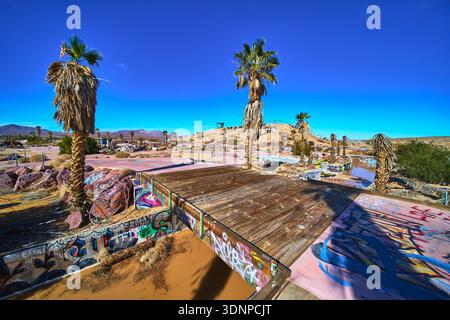 Parco acquatico abbandonato coperto di graffiti con palme nel deserto della California Foto Stock