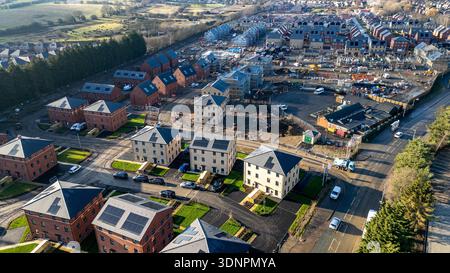 Veduta aerea di un nuovo complesso residenziale con edifici in mattoni e pietra, alcuni in costruzione con ponteggi, e del paesaggio circostante a Desi Foto Stock