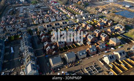 Veduta aerea di uno sviluppo abitativo suburbano in costruzione, caratterizzato da un mix di case completate e in corso, materiali da costruzione e vehi Foto Stock