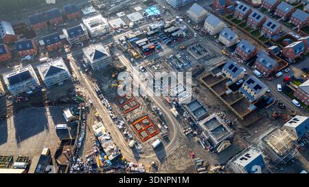 Veduta aerea di un edificio in costruzione, con fondazioni, case parzialmente costruite con impalcature e case completate a Desire Foto Stock