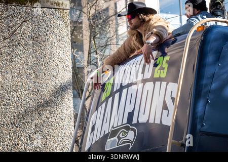 Seattle, Washington, Stati Uniti. 11 febbraio 2026. I Seattle Seahawks Tight End AJ Barner gestiscono lo striscione dei campioni del mondo sul fronte dell'autobus dei Seahawks durante la parata della vittoria del Super Bowl LX. (Nate Koppelman / Alamy Live News) Foto Stock