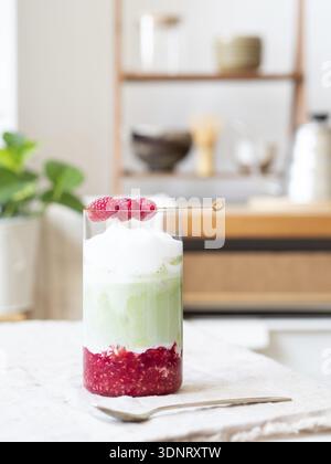 Latte matcha freddo a strati rinfrescante con purea di lamponi e condimento schiumoso Foto Stock