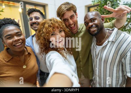 Colleghi d'affari felici che si divertono a lavorare di squadra e a trascorrere un momento insieme, illustrando diversità e collaborazione in un ufficio moderno o in uno spazio di coworking durante Foto Stock