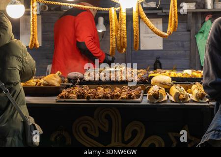 Una vivace banchina del mercato presenta un'allettante gamma di spiedini alla griglia, hot dog classici e noci di maiale, mettendo in risalto un vivace spettacolo notturno Foto Stock