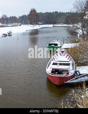 Piccole barche ormeggiate su un fiume tranquillo in inverno Foto Stock