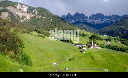 La Chiesa di Santa Maddalena in Val di Funes è incastonata tra prati lussureggianti con sullo sfondo la suggestiva catena delle Odle, che presenta un panorama mozzafiato Foto Stock