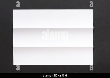 Foglio di carta piegato bianco su sfondo nero Foto Stock