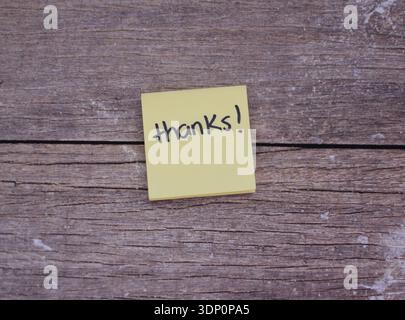 Post-it con la parola "ringraziamento" su tavolo in legno, vista dall'alto disposizione piatta Foto Stock