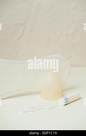 Scenografia con luce soffusa che presenta vari prodotti mestruali essenziali per il comfort e l'igiene femminile Foto Stock