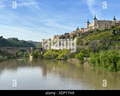 Storico ponte Puente de Alcantara sul fiume Tago e la città medievale di Toledo, Castiglia-la Mancha, Spagna, aprile 2024 Foto Stock