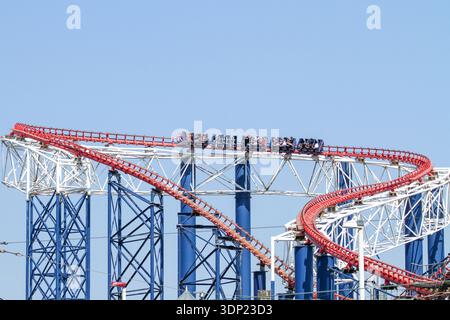 Persone che cavalcano le montagne russe a Blackpool Pleasure Beach in una giornata di sole, Lancashire, Inghilterra. Foto Stock