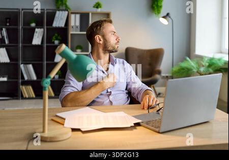 Ha preoccupato il lavoratore d'ufficio con disagio toracico alla scrivania nel quadro di un controllo contabile Foto Stock