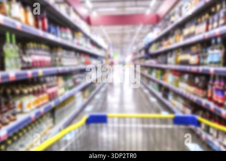 Sfondo sfocato. Varie bevande alcoliche sugli scaffali in un superstore. Sfocatura astratta nel supermercato per lo sfondo Foto Stock