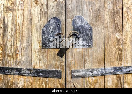 Vecchia porta in legno con lucchetto in metallo arrugginito da vicino Foto Stock