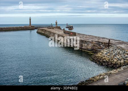 Whitby East Pier e faro, con West Pier e il faro oltre, nella storica cittadina costiera di Whitby nel North Yorkshire, Inghilterra, Regno Unito Foto Stock