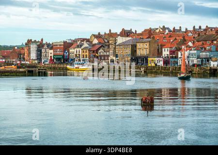 Edifici lungo la banchina sulla riva occidentale del fiume Esk, nella storica cittadina costiera di Whitby nel North Yorkshire, Inghilterra, Regno Unito Foto Stock