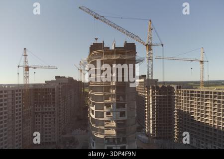 Costruzione di alti edifici multiappartamento. Cantiere. Diverse gru a torre. Foto Stock