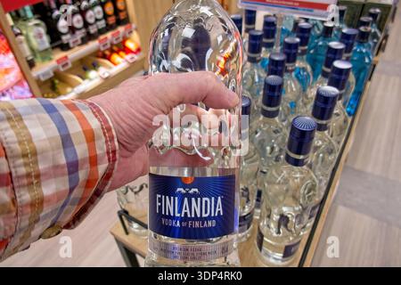 Helsinki, Finlandia, Europa - 22 maggio 2025: Bottiglia di vodka Finlandia tenuta a mano da uomo nell'area commerciale duty-free del traghetto Viking Line, M/S Viking XPRS. Foto Stock