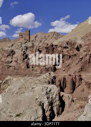 Strana formazione rocciosa e antiche rovine a Basgo, Ladakh, con rocce sedimentarie stratificate in un paesaggio aspro e arido Foto Stock