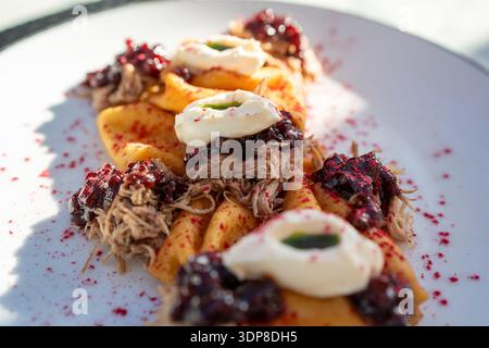 Primo piano di blini ricoperti di carne e panna Foto Stock