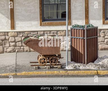 un vecchio carrello arrugginito in mostra su un marciapiede a ouray, colorado Foto Stock