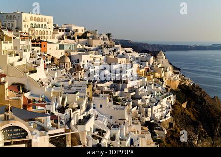 Fira, Santorini, Grecia: Edifici e hotel di colore bianco si aggrappano alla scogliera della caldera, offrendo ai turisti e al resid splendide vedute del Mar Egeo Foto Stock