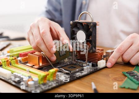 Utilizzo dell'hardware del computer con una scheda madre e un processore in un'area di lavoro Foto Stock