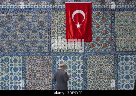 Istanbul, Turchia. 12 ottobre 2021 Un uomo prega di fronte alle belle piastrelle Iznik fuori dalla tomba di Abu Ayyub al-Ansari nella moschea Eyup Sultan Foto Stock