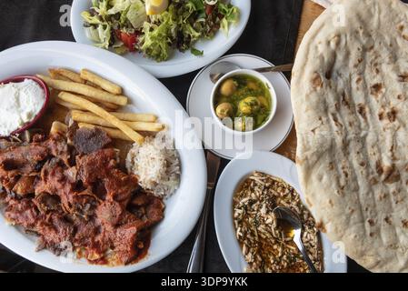 Alanya, Turchia. 8 Aprile 2021 piatto di Iskender o Bursa Kebab con mezze turche e pane tradizionale. Cucina tipica locale in Turchia Foto Stock