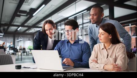 Diversi gruppi di studenti collaborano nel laboratorio di computer della scuola superiore. Foto Stock